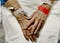 An elderly woman’s hands with IVs and hospital bracelets.