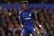 Tammy Abraham in the centre of the frame wearing Chelsea’s home kit with out of focus shot of crowd in the background
