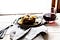 Meat on plate, drink on the side, backlit by white light,