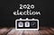 Black and white clock showing Tue 3 under 2020 election header