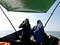Two young researchers holding binoculars and sitting in the bow of a boat, scanning the sea for dolphins and porpoises