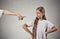 Image of an arm pointing at a girl who looks defient