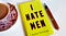 “I Hate Men” book laying on a desk next to a cup of tea and a pen.