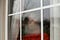 Black woman looking out the window with a forlorn expression.