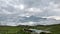 A picture from the mountain top, of clouds over the horizon, and a peak to be seen.