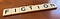 Letter tiles spelling out “Fiction” on a wooden desktop