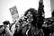 Black and white photo of a Black woman speaking into a microphone at a protest.