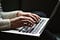 Two hands placed on the keyboard of a laptop