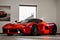 Red sports car in a dealer showroom.