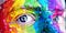 Close on a pair of eyes in a face splattered with rainbow paint