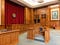 Old-style courtroom with lots of wood and maroon velvet drapes
