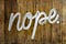 The word ”nope” written in paint on a fence