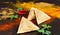 Samosas lie on a worktop next to a few sprigs of coriander and chillies.