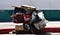 An unhoused person’s possessions in a red shopping cart on a street.