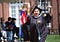21 year old Ariana, wearing a black graduation robe, holding a puerto rican flag as they walk to get their degree.