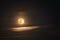 Shining moon and a long thin white cloud.