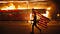 A protester carries an upside-down American flag past a burning liquor store in Minneapolis