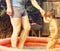 Small child in paddling pool holding her father’s hand