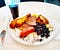 Full plate of various meats, drumsticks, beans, sausage, rice, and a glass of wine.