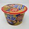 An unopened cup of Samyang Ramen Gold in a photo that features the top and front of the cup.