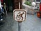 An erroneous wheelchair sign in disneyland depicts the user getting up out of it to get ready for a ride.