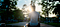 Person sitting, sun rising shining light in background.