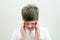 young boy holding both temples, squiting eyes due to a headache