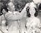 A man places a crown on Penny Lee Wong’s head. Wong is smiling and holding a bouquet of flowers.