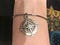 A silver bracelet with a compass charm.