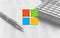 Microsoft logo over an image of a calculator, pen, and printed table chart.