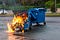 Picture of a dumpster on fire in street.