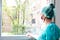Female nurse wearing a mask looking out the window.