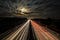 Night sky with time-lapse image of cars driving on highway.