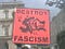 Orange sign with fist punching a swastika. “Destroy Fascism”