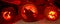 Three impressively carved pumpkins. 1. A witch sat on a crescent moon. 2. A wolf howling. 3. A spooky forest.