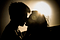 Woman and man kissing with sun in background.