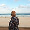A man looking at the crystal blue water beach in Brisbane, Australia.