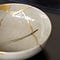 Close up of gold paint along the cracks of a bowl as an example of kintsugi.
