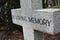 Grave marker — cross with “In Loving Memory” inscribed on it