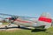 Silver Cessna 140 (N3527V) parked outside hangar at Poplar Grove Airport (C77) on sunny day