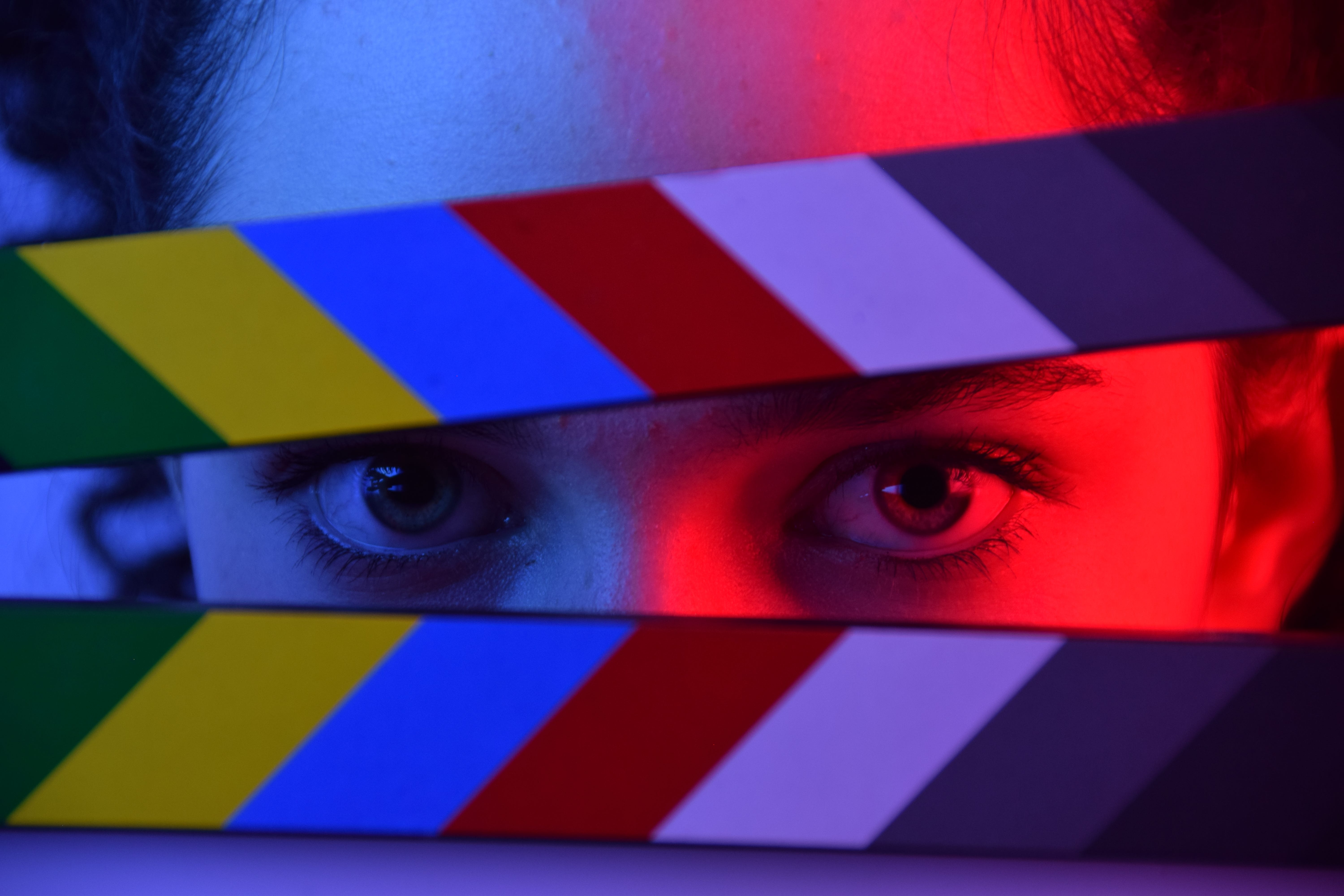 Close-up of a person looking through a clapperboard.