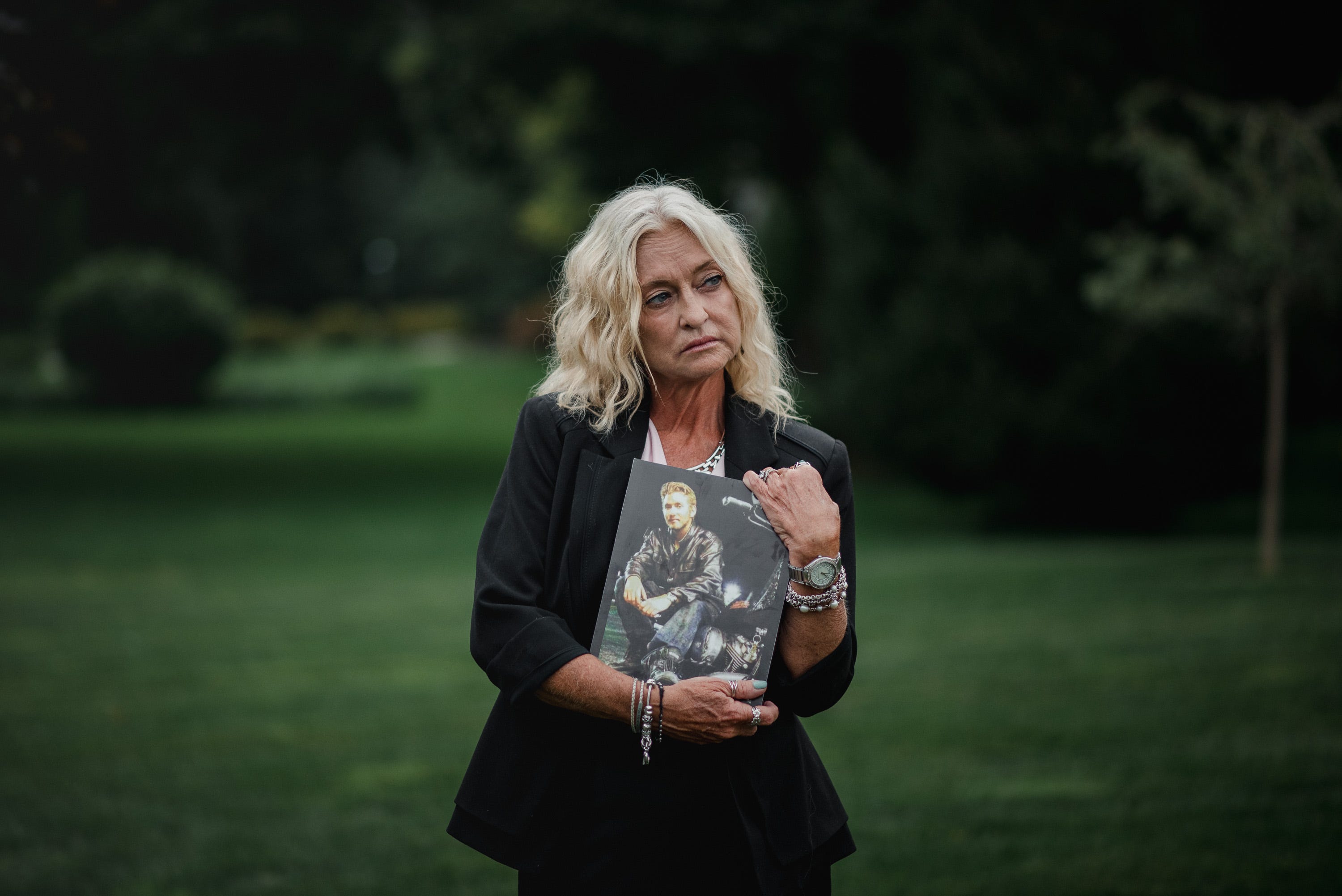Mary Kief stands for a portrait while holding an old photo of her son, Benjamin