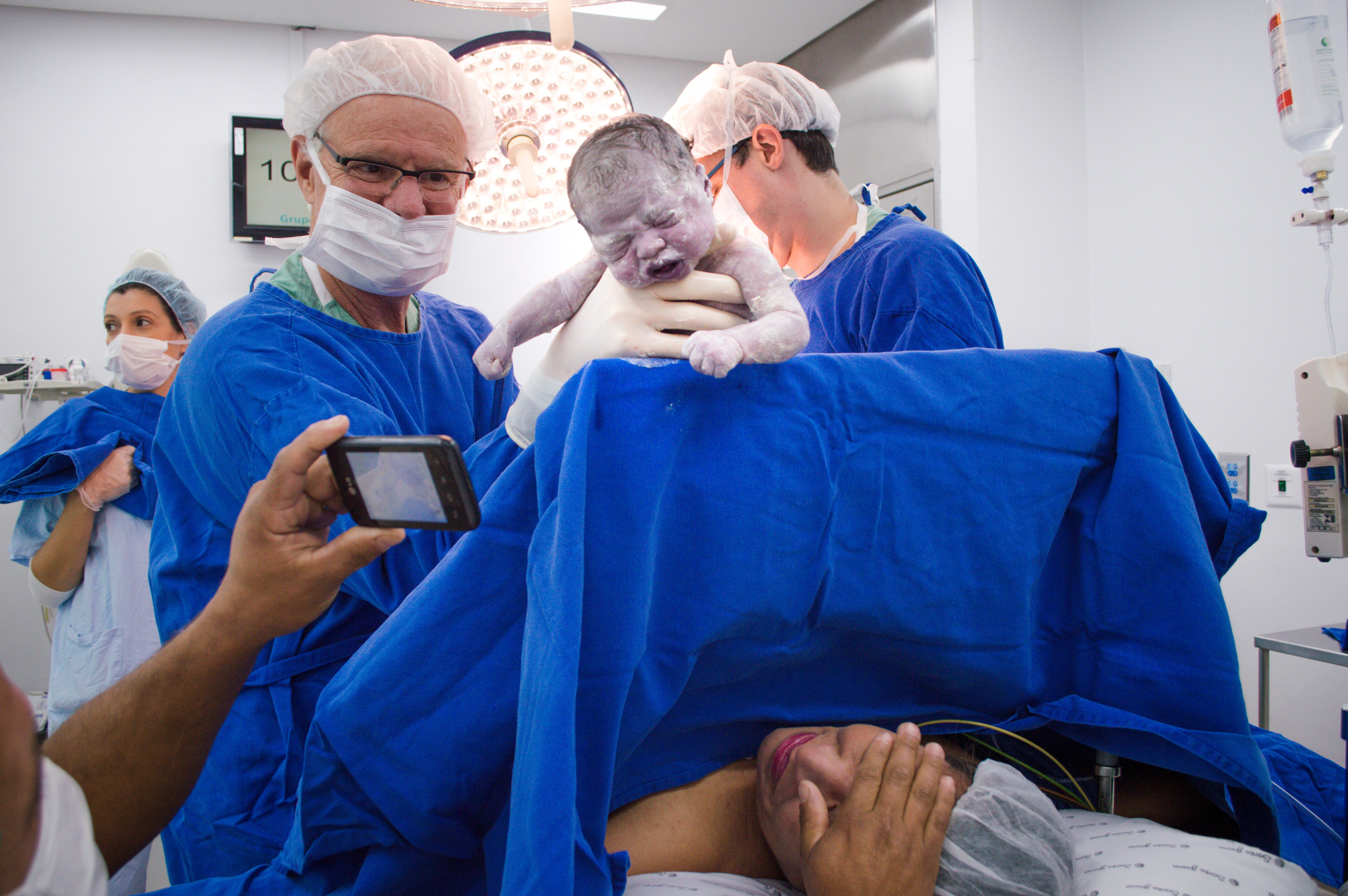 Pai fotografa bebê recém-nascido no Hospital Santa Joana, São Paulo/SP, Brasil