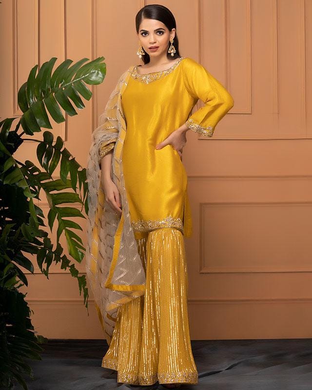 Silk Yellow Zari Work Sharara Suit Set with a classic gharara pant and sumptuous pair of earrings.