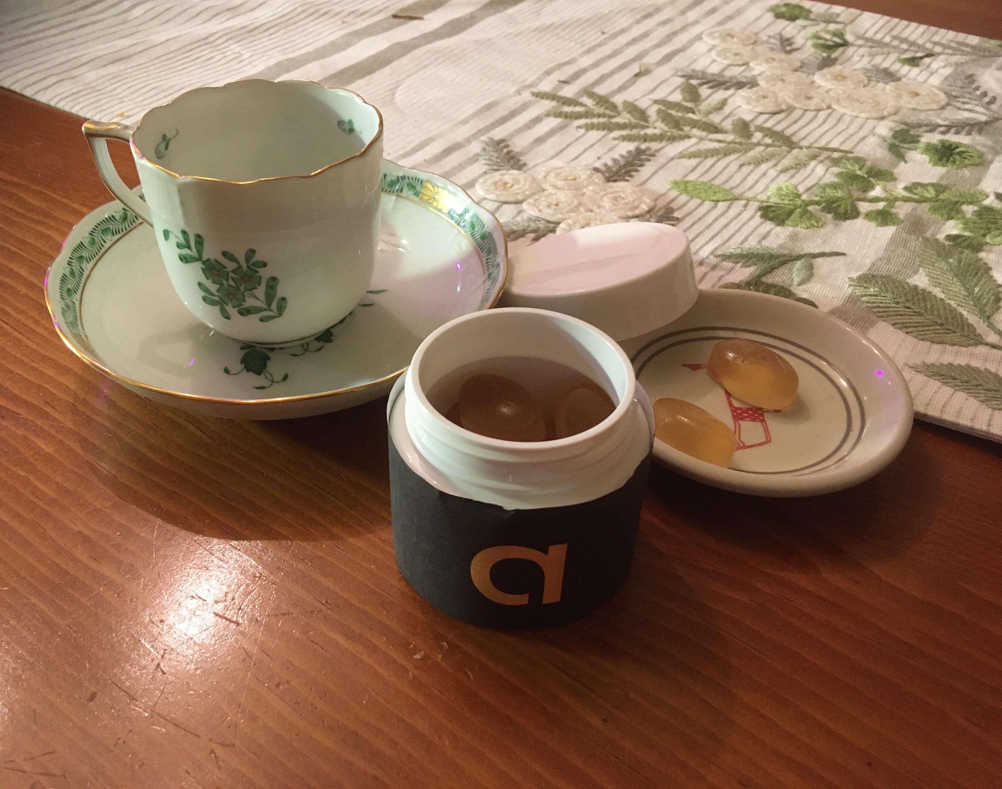 Teacup and gummies on table.