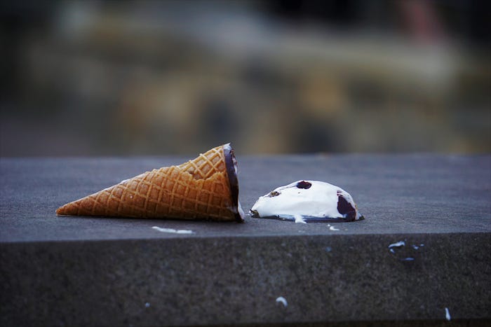 an icecream with the top melted on concrete