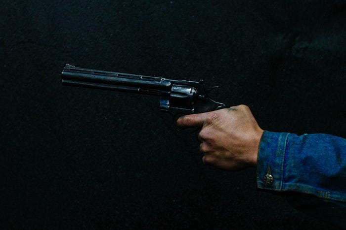 Image of a black hand holding a gun