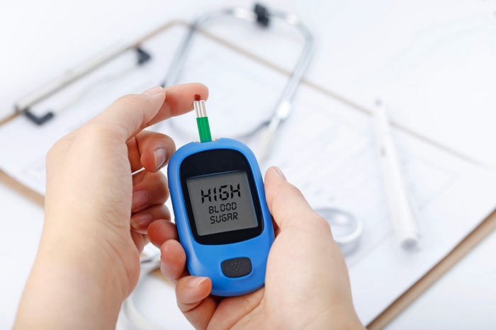 A human testing blood sugar through a glucometer.
