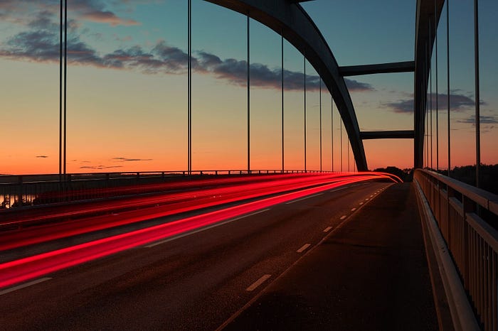 Barrido de luz en un puente durante el atardecer.