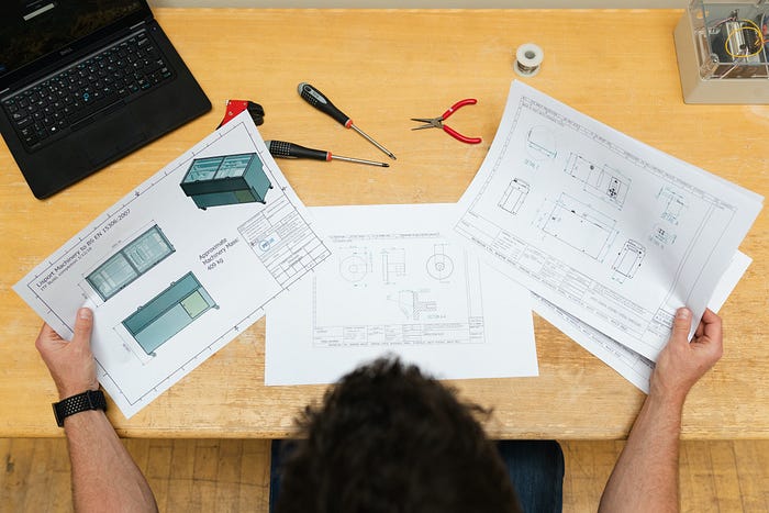 Person looking at technical drawings on landscape A4 papers